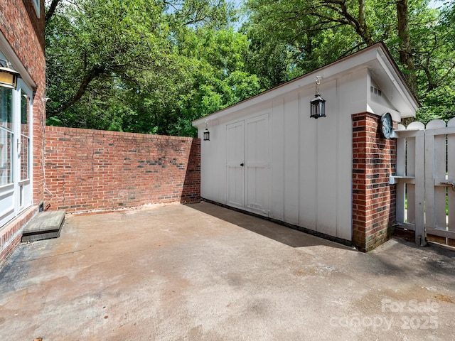 1411 Kensington Rd Unit C-1, Hendersonville, NC 28791 - view of patio featuring an outdoor structure and view of wooded area