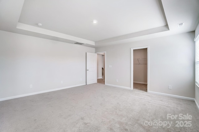 1700 Honey Trl, Monroe, NC 28112 - unfurnished bedroom with a tray ceiling, carpet floors, and a walk in closet