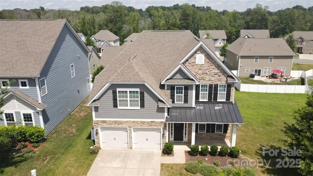 128 Carolina Ash Ln, Mooresville, NC 28117 - view of front of house with stone siding, an attached garage, driveway, and a porch