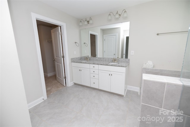 128 Carolina Ash Ln, Mooresville, NC 28117 - bathroom with double vanity, tile patterned flooring, a bath, and a walk in closet