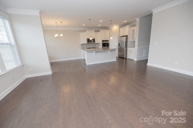 128 Carolina Ash Ln, Mooresville, NC 28117 - unfurnished living room featuring crown molding, a chandelier, recessed lighting, plenty of natural light, and dark wood-style flooring
