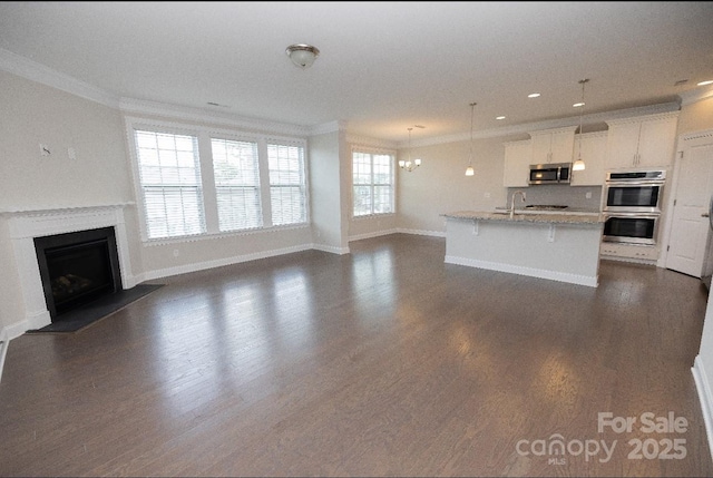 128 Carolina Ash Ln, Mooresville, NC 28117 - unfurnished living room with ornamental molding, dark wood-type flooring, a fireplace, and recessed lighting