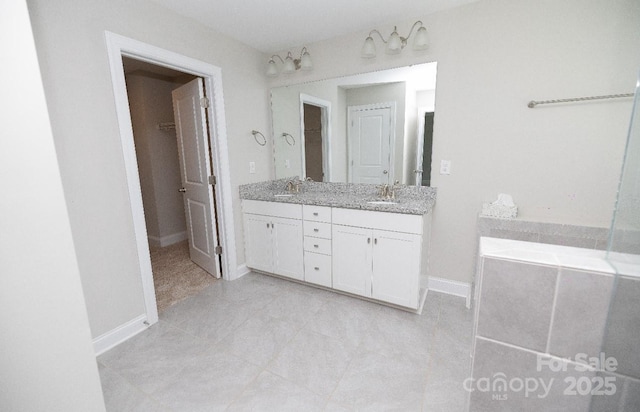 128 Carolina Ash Ln, Mooresville, NC 28117 - full bathroom featuring double vanity, tile patterned floors, a tub to relax in, and a walk in closet