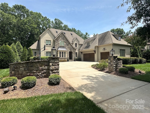 7816 Clovervale Dr, Waxhaw, NC 28173 - french country home featuring stone siding, driveway, an attached garage, and stucco siding