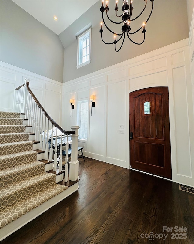7816 Clovervale Dr, Waxhaw, NC 28173 - foyer entrance with a decorative wall, high vaulted ceiling, a chandelier, dark wood-style floors, and stairs