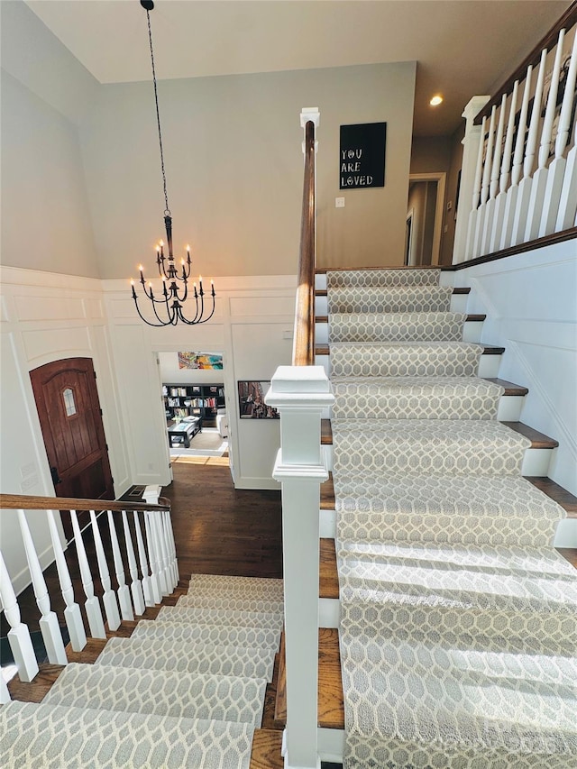 7816 Clovervale Dr, Waxhaw, NC 28173 - stairway featuring a decorative wall, wood finished floors, a chandelier, recessed lighting, and a wainscoted wall