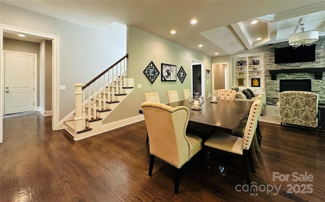 7816 Clovervale Dr, Waxhaw, NC 28173 - dining room with stairs, dark wood-style floors, built in shelves, a stone fireplace, and recessed lighting