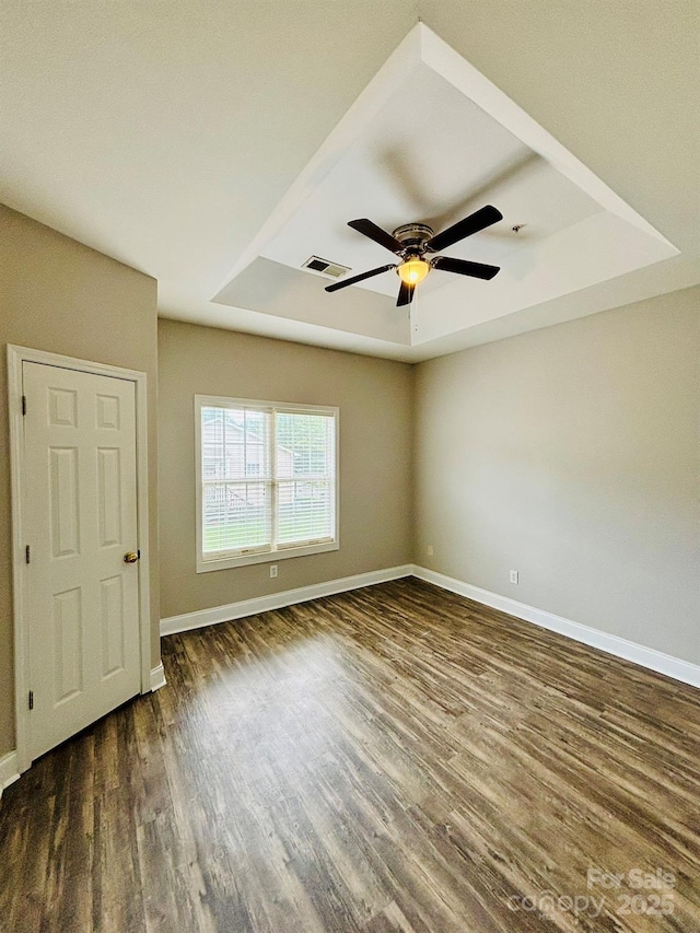 917 Shearer St Unit 15, Davidson, NC 28036 - spare room featuring a tray ceiling, dark wood-type flooring, and ceiling fan