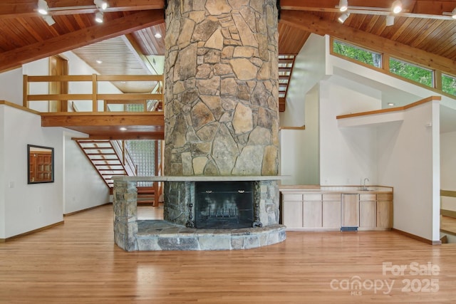 295 Dills Rd, Bryson City, NC 28713 - unfurnished living room with a wood ceiling with exposed beams, stairs, wood finished floors, high vaulted ceiling, and a stone fireplace