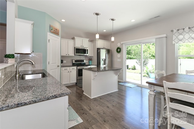 201 Fesperman Cir, Troutman, NC 28166 - kitchen with appliances with stainless steel finishes, backsplash, white cabinets, dark wood-type flooring, and a kitchen island