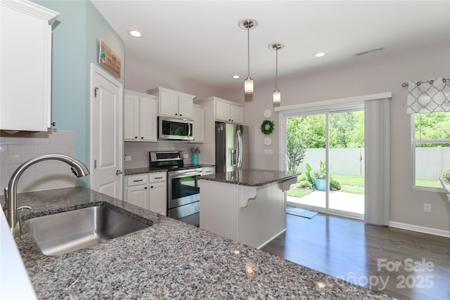 201 Fesperman Cir, Troutman, NC 28166 - kitchen featuring stainless steel appliances, dark wood finished floors, white cabinets, tasteful backsplash, and dark stone countertops