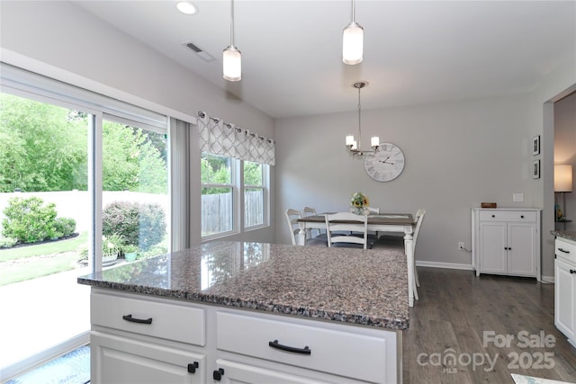 201 Fesperman Cir, Troutman, NC 28166 - kitchen with a chandelier, dark wood-type flooring, white cabinetry, dark stone counters, and hanging light fixtures