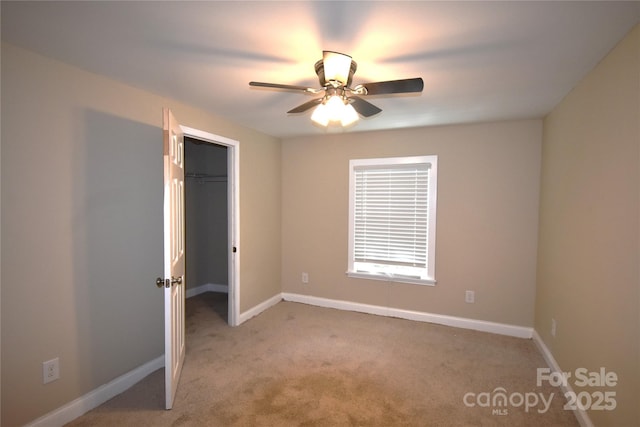 6264 Burnhurst Ln, Denver, NC 28037 - unfurnished bedroom featuring a walk in closet, light carpet, and a ceiling fan