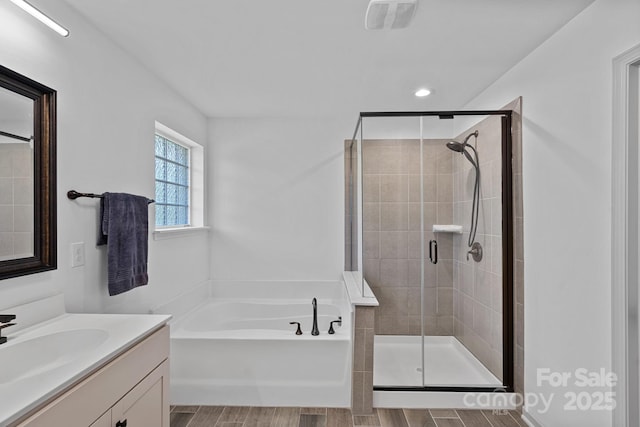 161 Oxford Dr, Mooresville, NC 28115 - full bathroom with vanity, a garden tub, a stall shower, recessed lighting, and wood finished floors