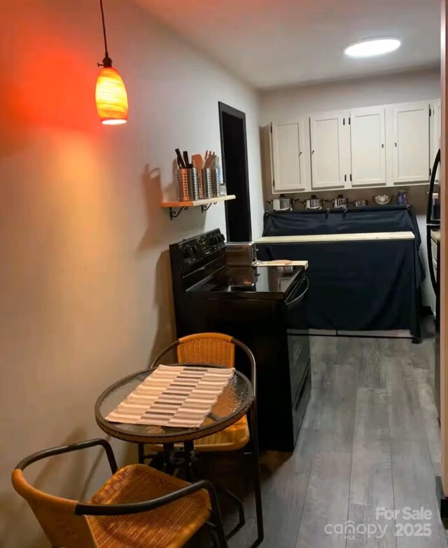 60 Walden Pond Rd, Bryson City, NC 28713 - kitchen featuring black range with electric cooktop, white cabinetry, pendant lighting, a peninsula, and wood finished floors