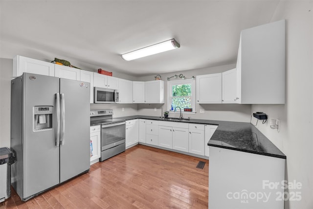 369 Birch Circle Dr, Hudson, NC 28638 - kitchen featuring appliances with stainless steel finishes, light wood finished floors, and white cabinets