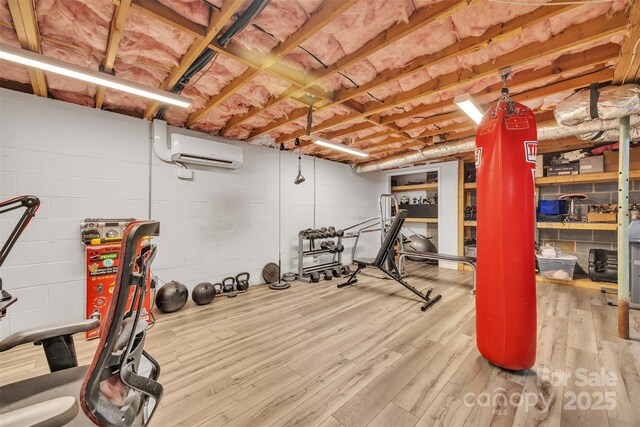 369 Birch Circle Dr, Hudson, NC 28638 - workout area featuring a wall unit AC, wood finished floors, and concrete block wall
