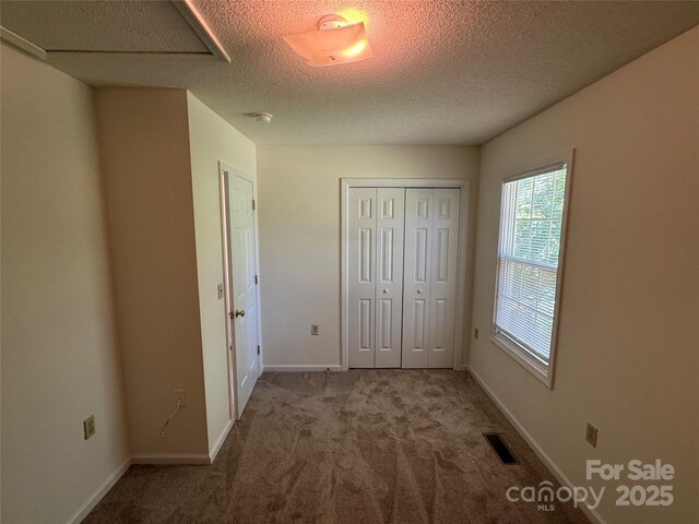 972 NW 8th Ave, Hickory, NC 28601 - unfurnished bedroom with carpet floors, a closet, a textured ceiling, and attic access