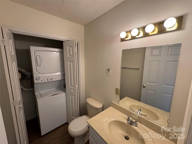 972 NW 8th Ave, Hickory, NC 28601 - bathroom featuring estacked washer and dryer, wood finished floors, vanity, and a textured ceiling