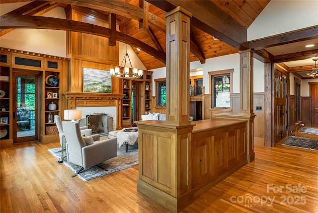 14 Clear Fork Ln, Fairview, NC 28730 - living room featuring ornate columns, a chandelier, light wood-type flooring, a wainscoted wall, and a fireplace