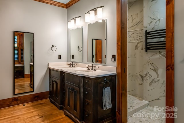 14 Clear Fork Ln, Fairview, NC 28730 - bathroom with double vanity, ornamental molding, a marble finish shower, wood finished floors, and radiator