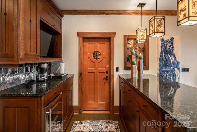 14 Clear Fork Ln, Fairview, NC 28730 - kitchen with brown cabinetry, dark stone counters, ornamental molding, and decorative light fixtures
