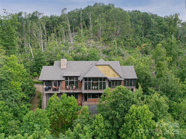 14 Clear Fork Ln, Fairview, NC 28730 - back of property with a sunroom, a chimney, a forest view, a shingled roof, and a wooden deck