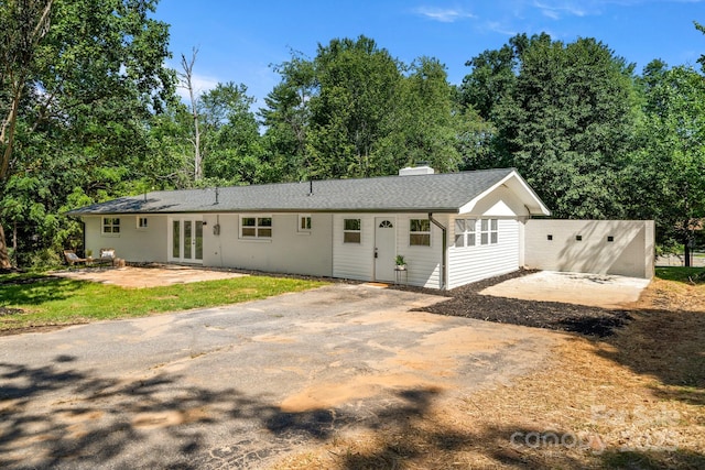 6672 Brevard Rd, Etowah, NC 28729 - ranch-style house featuring french doors, a patio, a chimney, and view of wooded area