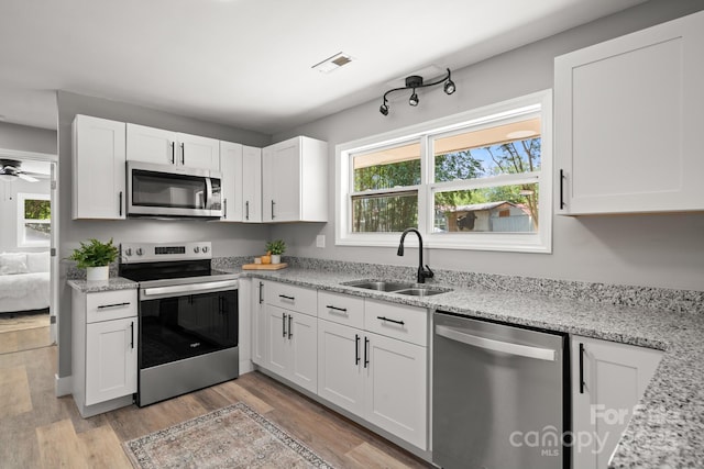 6672 Brevard Rd, Etowah, NC 28729 - kitchen with stainless steel appliances, plenty of natural light, and white cabinetry