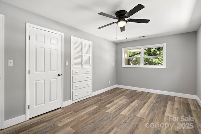 6672 Brevard Rd, Etowah, NC 28729 - unfurnished bedroom featuring wood finished floors and a ceiling fan