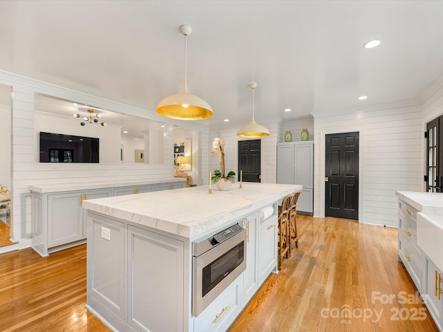 2912 Wheelock Rd, Charlotte, NC 28211 - kitchen featuring a center island, white cabinets, a breakfast bar, recessed lighting, and light wood finished floors