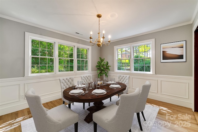 197 Briar Patch Rd, Cullowhee, NC 28723 - dining area with a chandelier, crown molding, wainscoting, a decorative wall, and light wood-type flooring