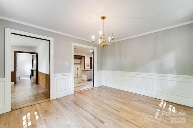 197 Briar Patch Rd, Cullowhee, NC 28723 - unfurnished dining area featuring a chandelier, crown molding, light wood-style floors, and a wainscoted wall