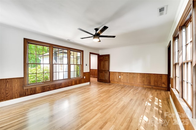 197 Briar Patch Rd, Cullowhee, NC 28723 - empty room featuring wainscoting, light wood finished floors, wooden walls, and a ceiling fan