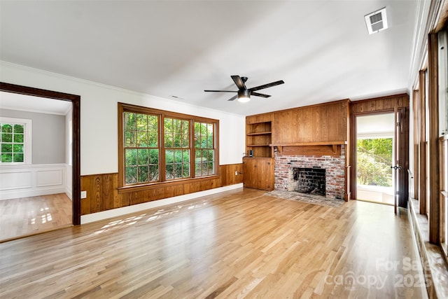 197 Briar Patch Rd, Cullowhee, NC 28723 - unfurnished living room with wainscoting, ceiling fan, built in shelves, a fireplace, and light wood finished floors