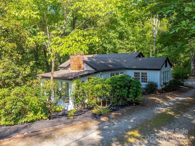 197 Briar Patch Rd, Cullowhee, NC 28723 - view of front of home featuring driveway, a chimney, and a forest view