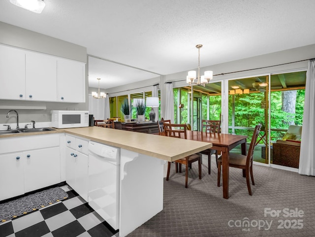 140 W Lake Dr Unit 301, Lake Lure, NC 28746 - kitchen featuring a chandelier, white appliances, a peninsula, light countertops, and white cabinets