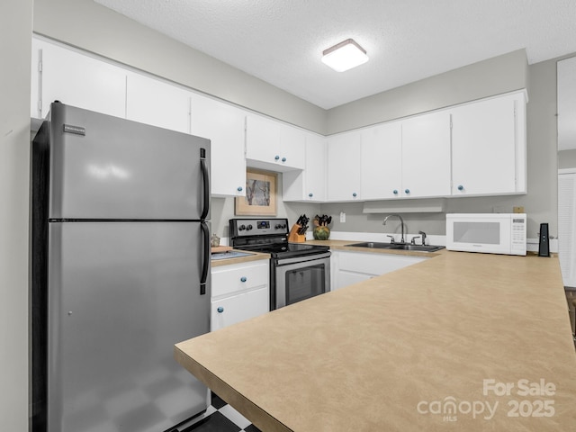140 W Lake Dr Unit 301, Lake Lure, NC 28746 - kitchen with stainless steel appliances, a textured ceiling, light countertops, and white cabinets