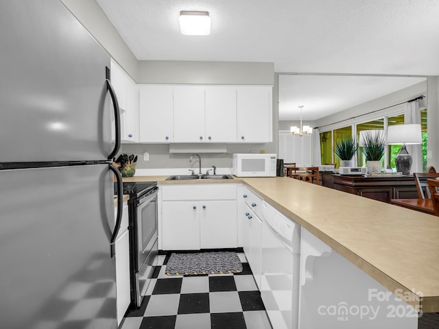140 W Lake Dr Unit 301, Lake Lure, NC 28746 - kitchen with stainless steel appliances, dark floors, a chandelier, light countertops, and white cabinetry