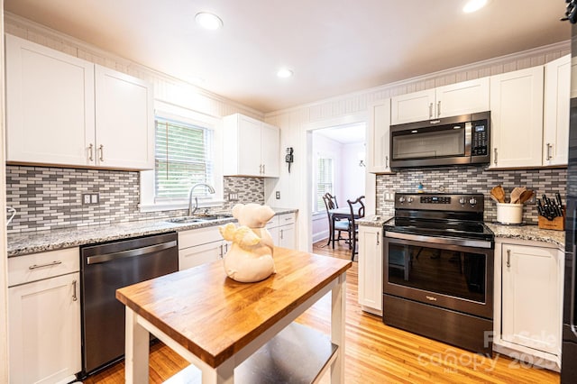 122 15th Ave NW, Hickory, NC 28601 - kitchen with stainless steel appliances, white cabinets, tasteful backsplash, light wood-type flooring, and crown molding