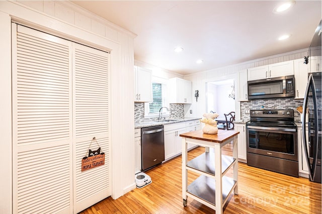 122 15th Ave NW, Hickory, NC 28601 - kitchen with stainless steel appliances, decorative backsplash, white cabinets, light wood-type flooring, and crown molding