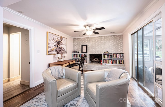 122 15th Ave NW, Hickory, NC 28601 - living area featuring ceiling fan, hardwood / wood-style flooring, ornamental molding, a brick fireplace, and brick wall