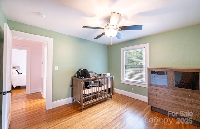 122 15th Ave NW, Hickory, NC 28601 - bedroom featuring light wood-style flooring, a nursery area, and a ceiling fan
