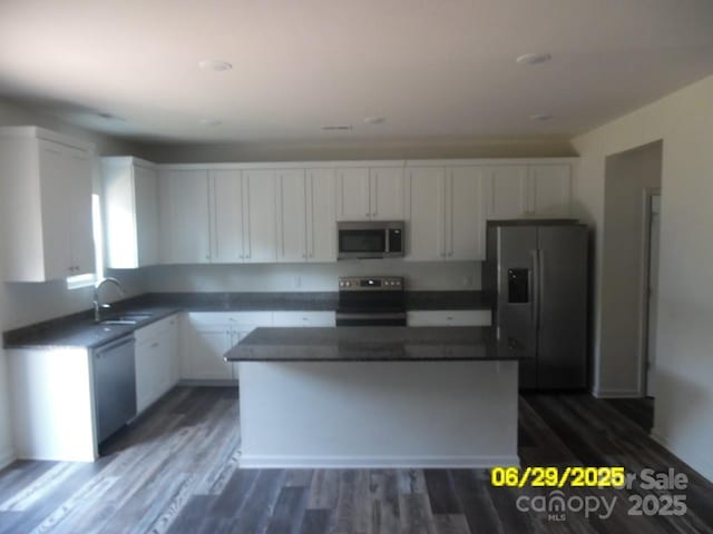 570 30th Avenue Cir NE, Hickory, NC 28601 - kitchen with appliances with stainless steel finishes, white cabinets, a kitchen island, dark countertops, and dark wood-style flooring