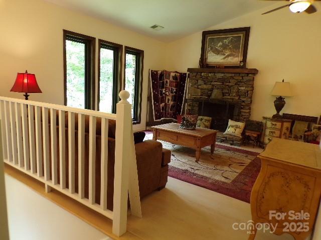 140 Beechwood Cir, Hendersonville, NC 28739 - living room featuring lofted ceiling, a ceiling fan, and a stone fireplace