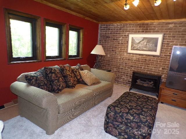 140 Beechwood Cir, Hendersonville, NC 28739 - living room featuring wood ceiling, healthy amount of natural light, carpet floors, brick wall, and a brick fireplace