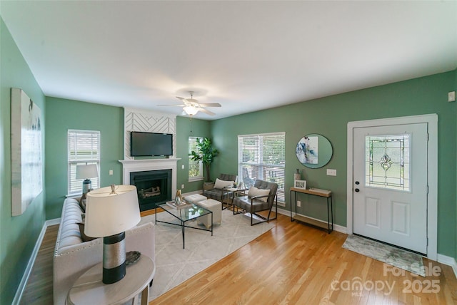 8509 Castle Cliff Dr, Matthews, NC 28105 - living area featuring healthy amount of natural light, a fireplace, ceiling fan, and wood finished floors