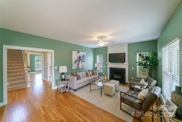 8509 Castle Cliff Dr, Matthews, NC 28105 - living area featuring light wood-style flooring, a ceiling fan, a large fireplace, and stairway