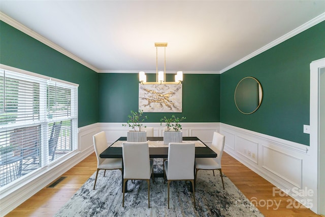 8509 Castle Cliff Dr, Matthews, NC 28105 - dining room featuring ornamental molding, wainscoting, wood finished floors, and a decorative wall