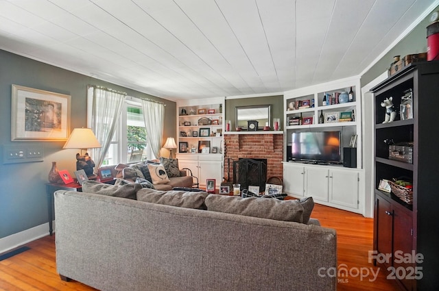 22 Poplar St, Belmont, NC 28012 - living area with wood finished floors, a brick fireplace, built in features, and crown molding